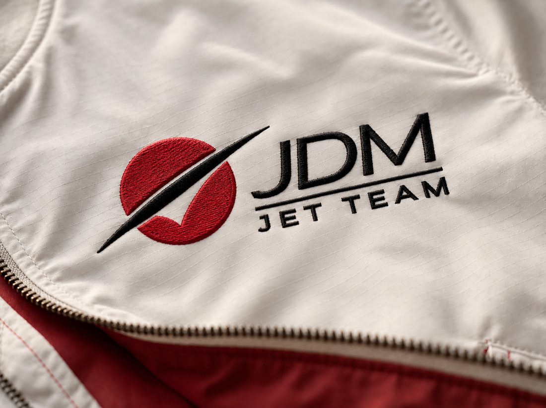 The team mark embroidered on a white flight jacket, close.